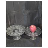Two clear glass pedestal cake stands.