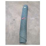 Rolled up green carpet unknown size.