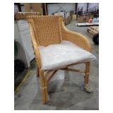 Rattan chair with beige cushion.