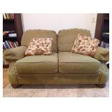 Green Fabric Love Seat with Floral Pillows