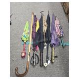 Assorted umbrellas and cane