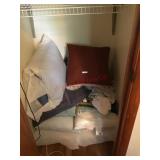 lot of throw pillows and bed pillows in closet