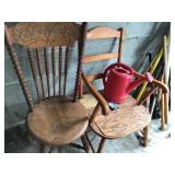 2 old wood chairs and water can