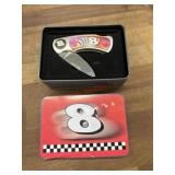 Small folding knife in tin container