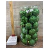 Container of green Christmas ornaments