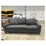 Damaged gray upholstered sofa