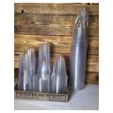Flat of open cups, lids, and pack of plastic cups