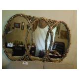 Gold wall mirror shaped like 3 interlocking Gold wall mirror shaped like 3 interlocking