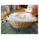 Wicker laundry basket with lace tablecloths,