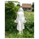 Cement statue of woman holding rose bouquet,