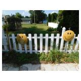 Pair of metal smiley faces on stakes