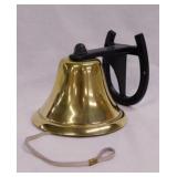 Vintage brass dinner bell on a black mini iron