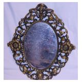 Oval wall mirror in ornate brass frame, 18" x 21"