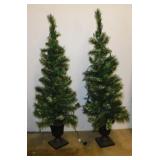 2 lighted flocked christmas trees in planters,