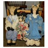 Hand crafted primitive folk art cow dolls on bench