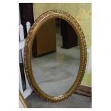 Heavy oval wall mirror in gilded ornate oak frame,