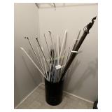 Black Round Trashcan Filled with Curtain Rods