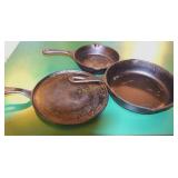 Several cast iron pans, wok, egg poacher &