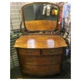 Antique bow front dresser with attached mirror.