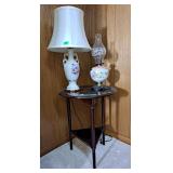 Side table, oil lamp, electric lamps and 2 prints