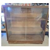 Vintage bookcase features sliding glass doors.