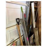 LOT OF MIXED TOOLS LEANING AGAINST DOOR