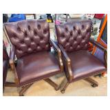 Two Burgundy Tufted Leather Swivel Chairs