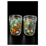 Two Glass Jars Filled With Colorful Marbles