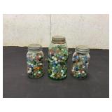 Three Glass Jars Filled With Assorted Marbles
