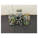 Three Glass Jars Containing Assorted Marbles