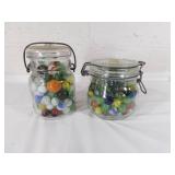 Two Glass Jars Containing Assorted Marbles