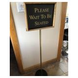 Wait to be seated sign