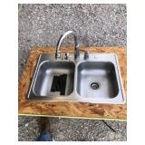Stainless kitchen sink with faucet.