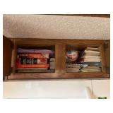 Assorted Kitchen Cabinet Contents Including Cookbooks and Storage Containers
