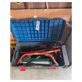 Storage Tote Containing Assorted Hand Saws and Garden Tools