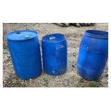 Three blue barrels for trash cans