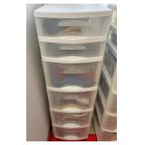 Six drawer plastic organizer full of linens mats