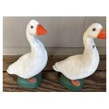 Two small concrete ducks one has chipped neck