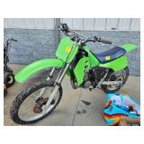 1985 KX DIRT BIKE WITH RAMP AND EXTRA PARTS.