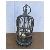 Metal bird cage with fake bird perched inside