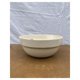 White stoneware mixing bowl with large crack on th