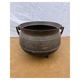 Cast iron footed pot. See picture for writing on t