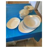 Duck serving dish and other white serving pieces.