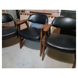 Four black vinyl and wood chairs