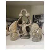 Hand carved stone sculptures appear to be from