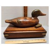 Wooden duck decoy on wood box.