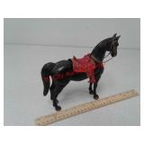 Black plastic toy horse with red saddle