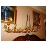 Large gold plaster candelabra above bed