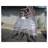 STACK OF BROWN PLASTIC SCHOOL CHAIRS: