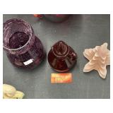 A purple cracked glass vase, a red Avon decanter
